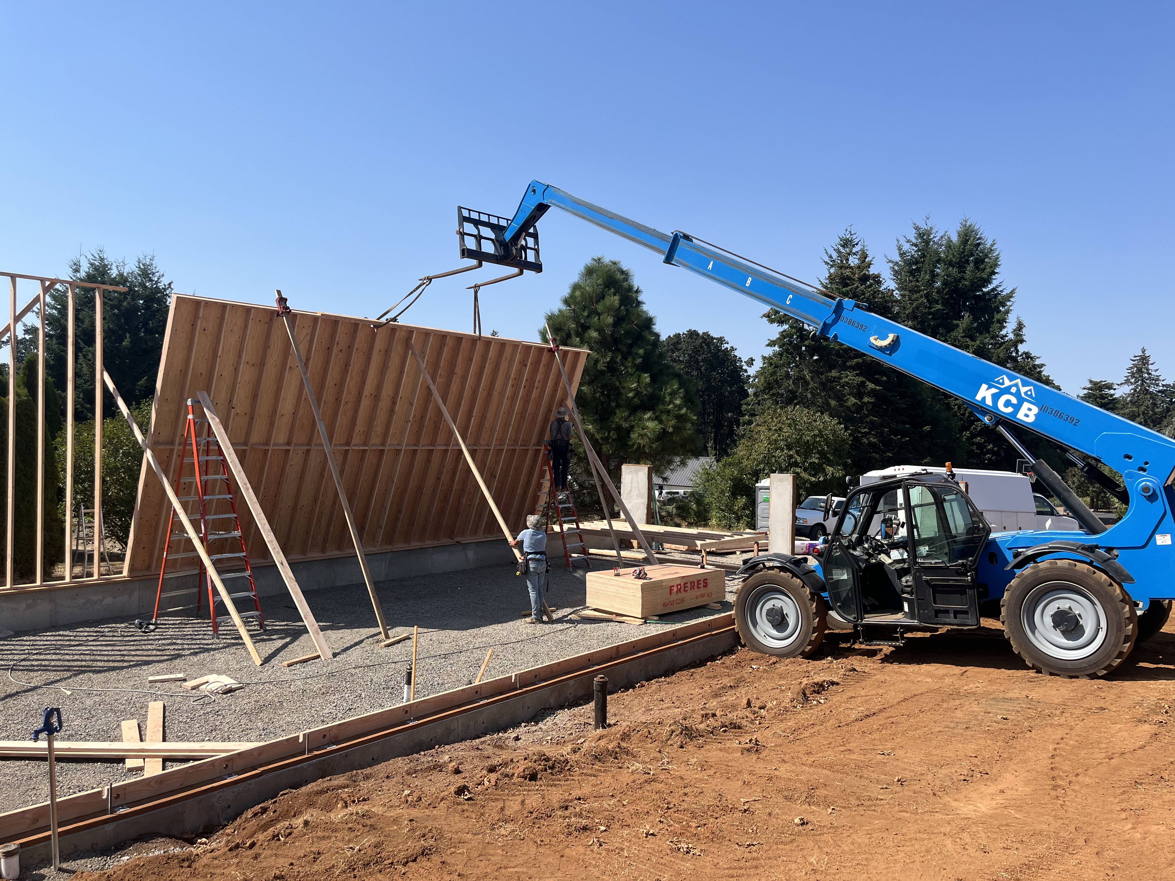 KCB crew lifting a framed wall panel into place